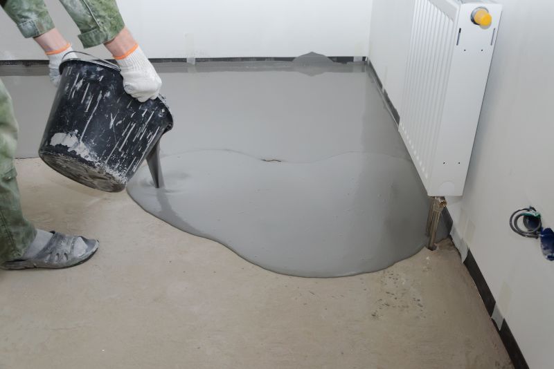 worker pouring epoxy mixture on the floor