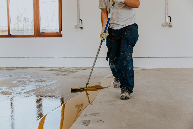 garage epoxy flooring townsville worker installing epoxy coating on garage flooring